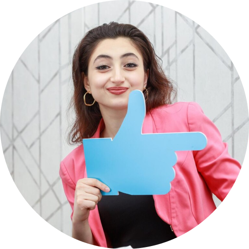 A woman smiling and giving a thumbs up sign, expressing positivity and approval.